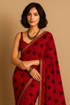 Model wearing Gulnaar Bandhini pre-draped chiffon saree in crimson red with golden zari border