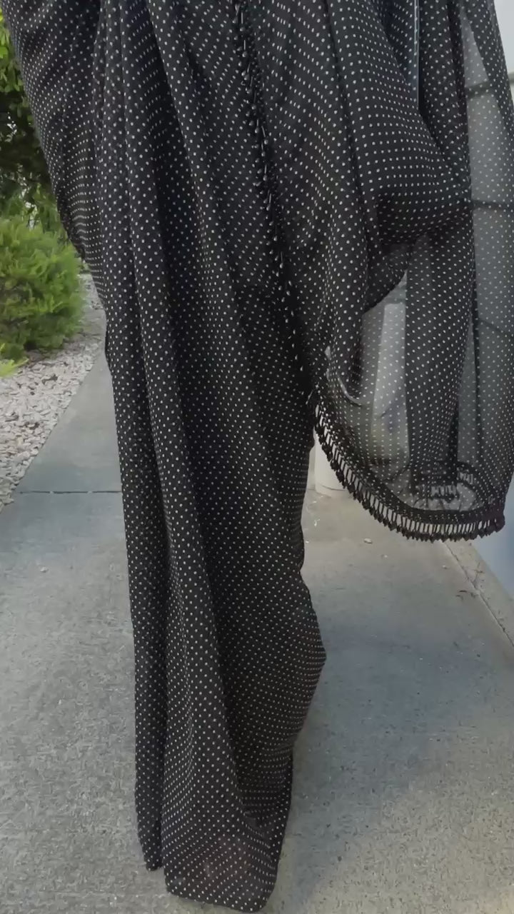 Woman wearing Cinema Classic black and white polka dot pre-draped georgette saree with beaded tassel pallu